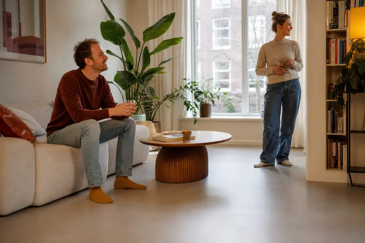 Vloerverwarming als hoofdverwarming in een modern Nederlands interieur met bewoners die ontspannen genieten